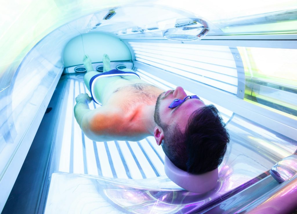 Young Man At Solarium In Beauty Salon.
